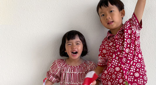 Kids waiting flags wearing red and white batik for national day