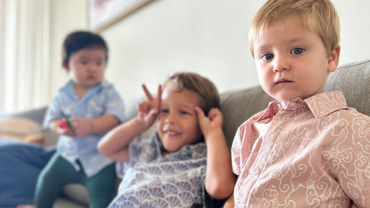 Three boys wearing artisan batik shirts in pastel colors