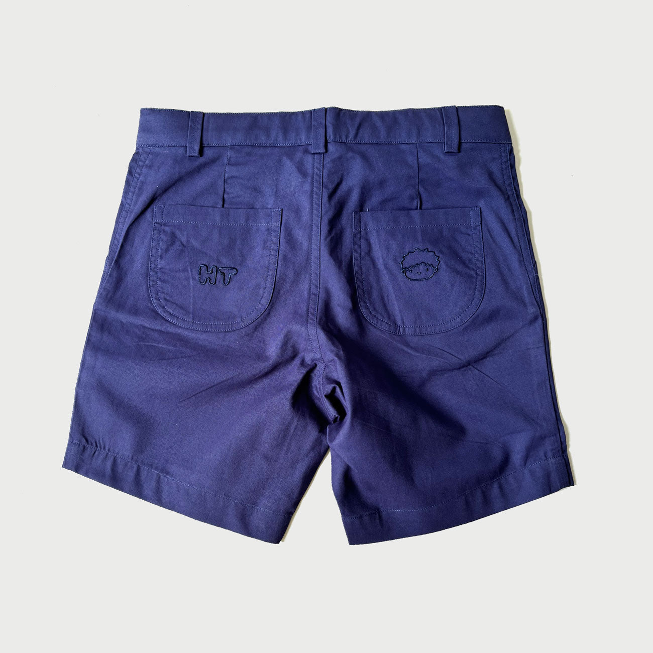 Back pockets of navy chino shorts for boys