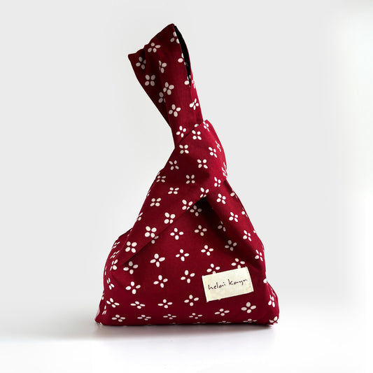 Red batik fabric, Korean-inspired knot bag with white floral pattern on a white background