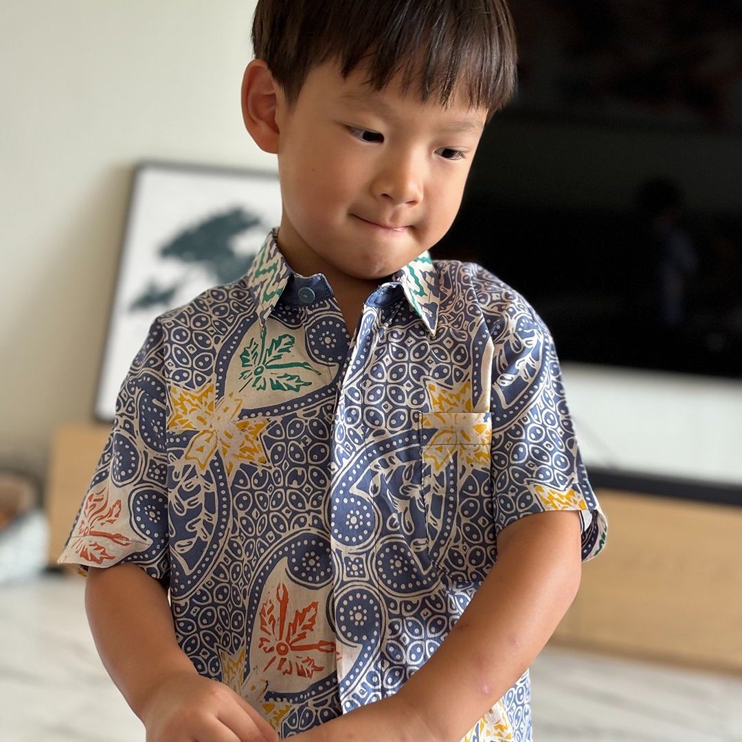 Model wearing blue batik shirt with kawung and sekar jagad patterns