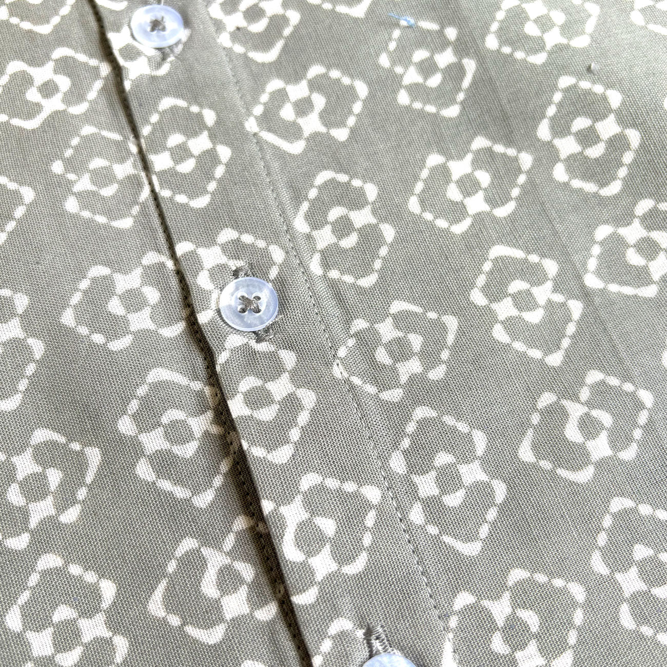 Buttons and fabric close up of gray batik shirt