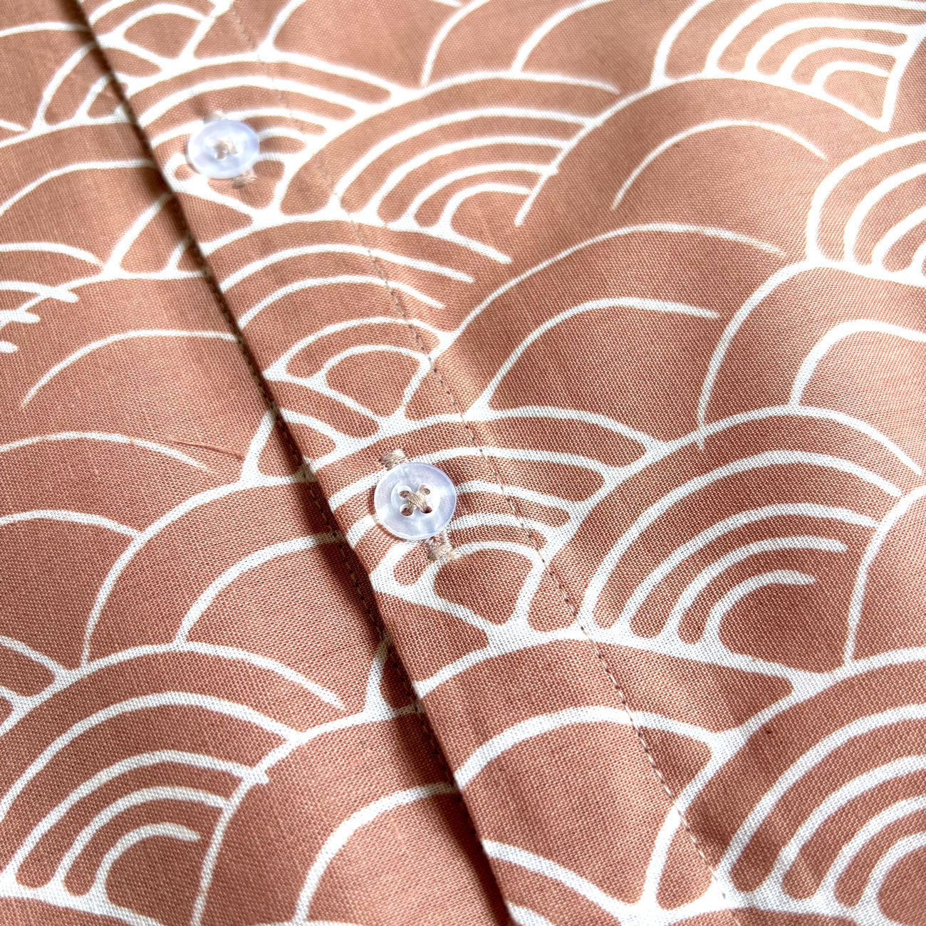 Close up of buttons sitting on batik shirt