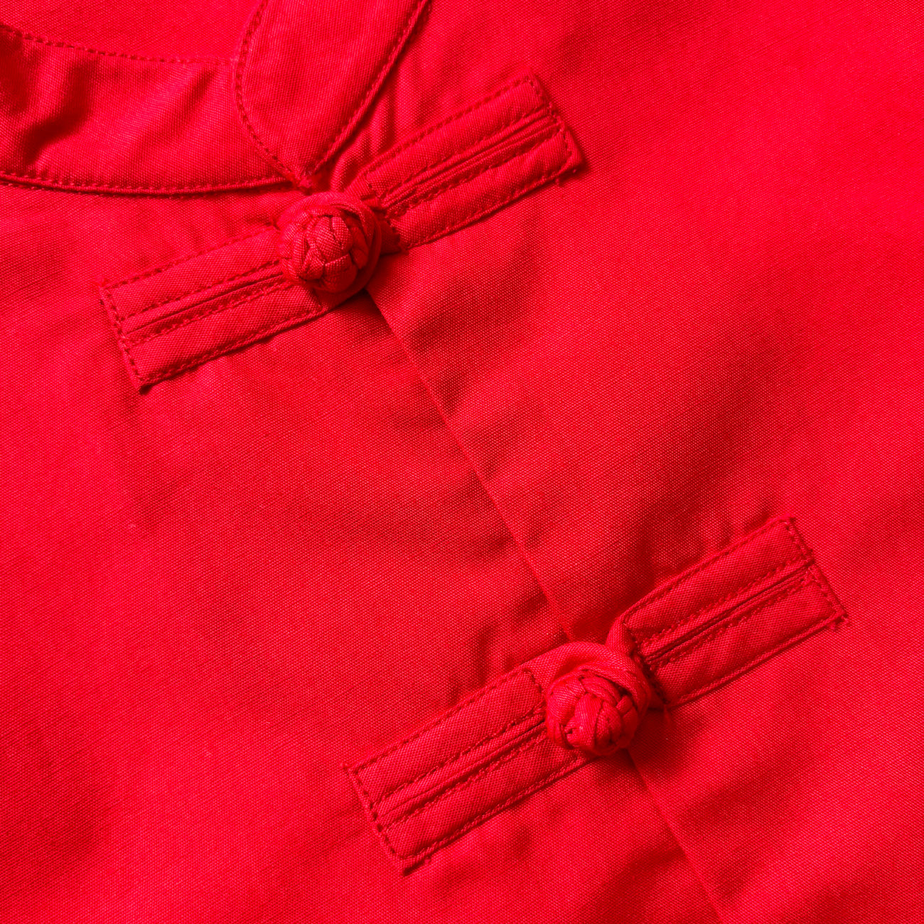 Close up of red frog buttons on a red cheongsam shirt