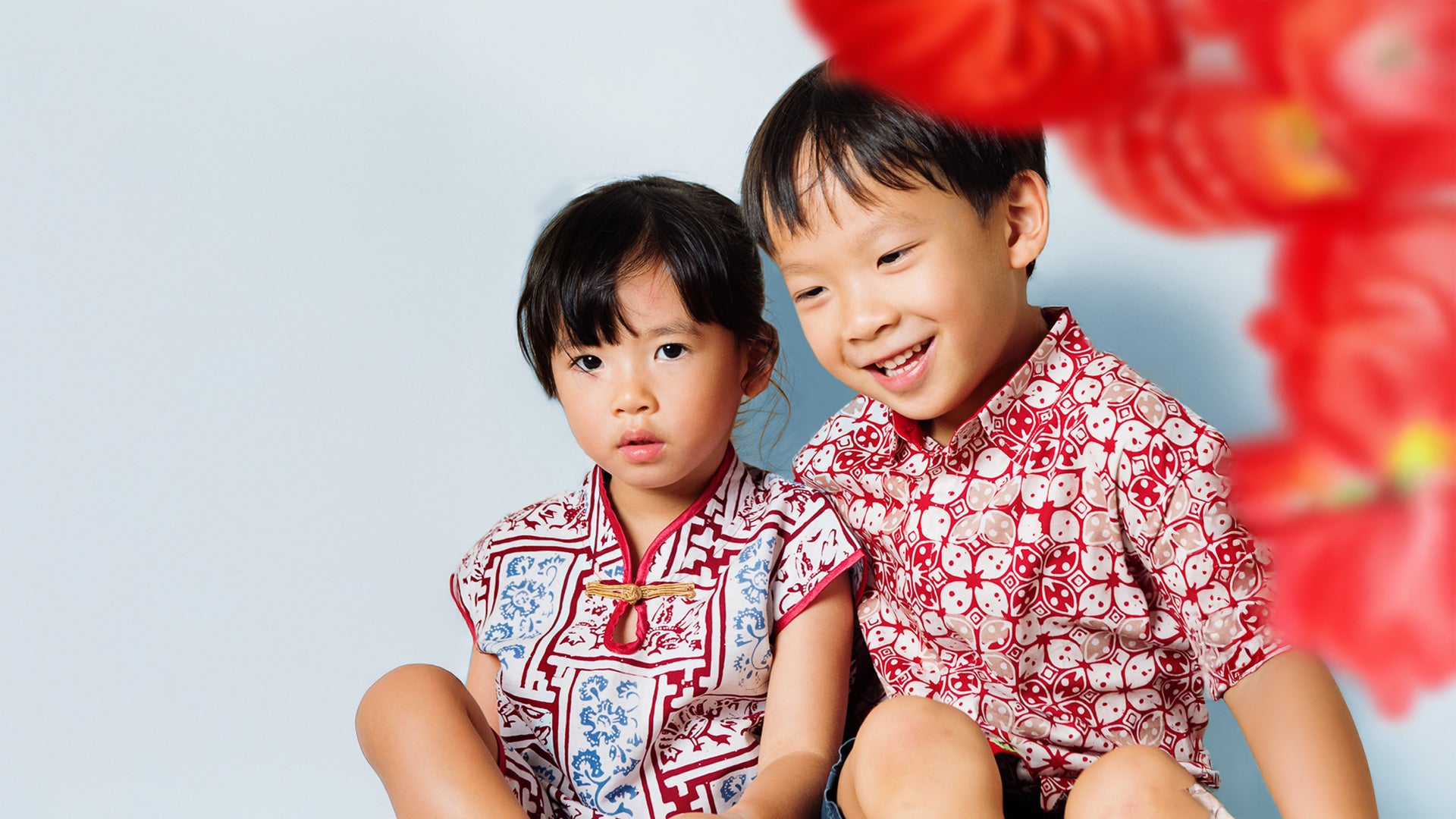 Boy and girl wearing Chinese New Year outfits
