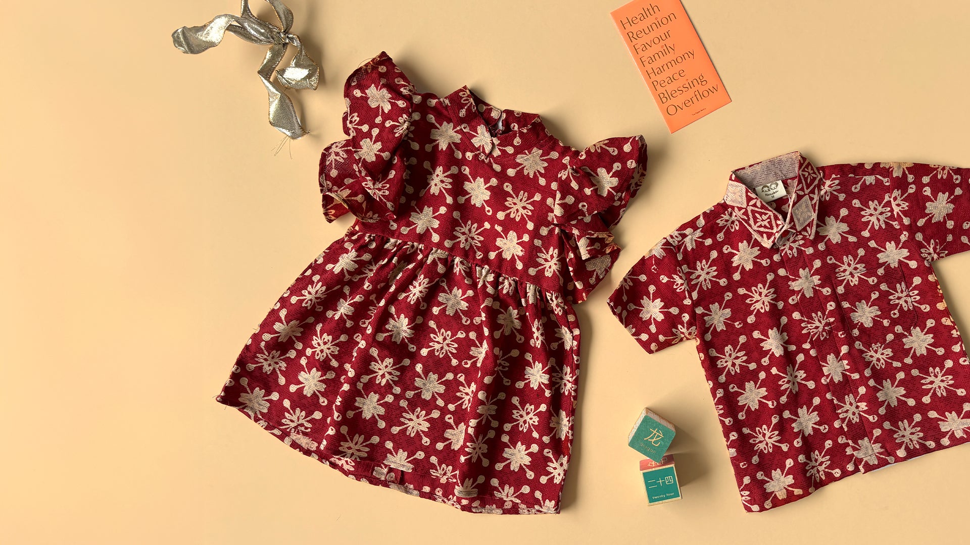 Flat lay of a matching red and gold cheongsam dress and batik shirt