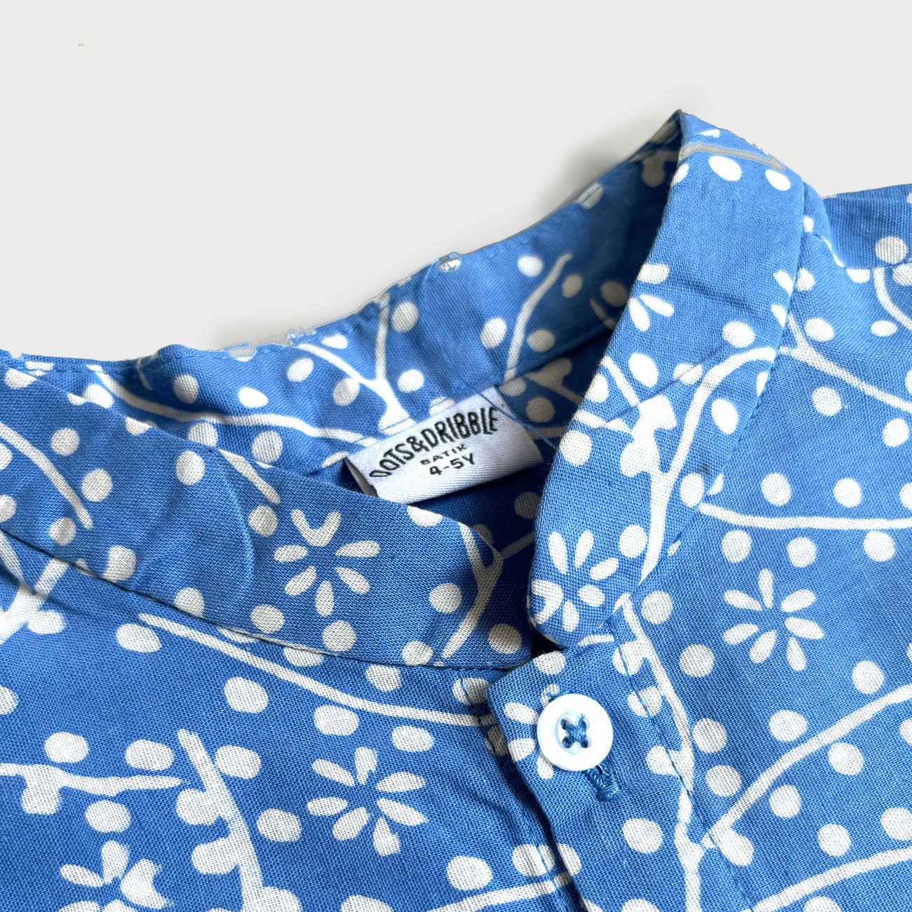 Close up of a mandarin collar of the blue batik shirt with floral design