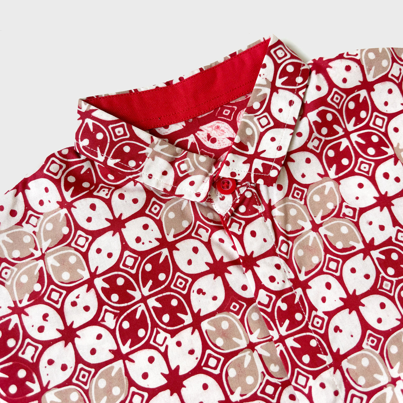 Collar and button details of a red batik shirt