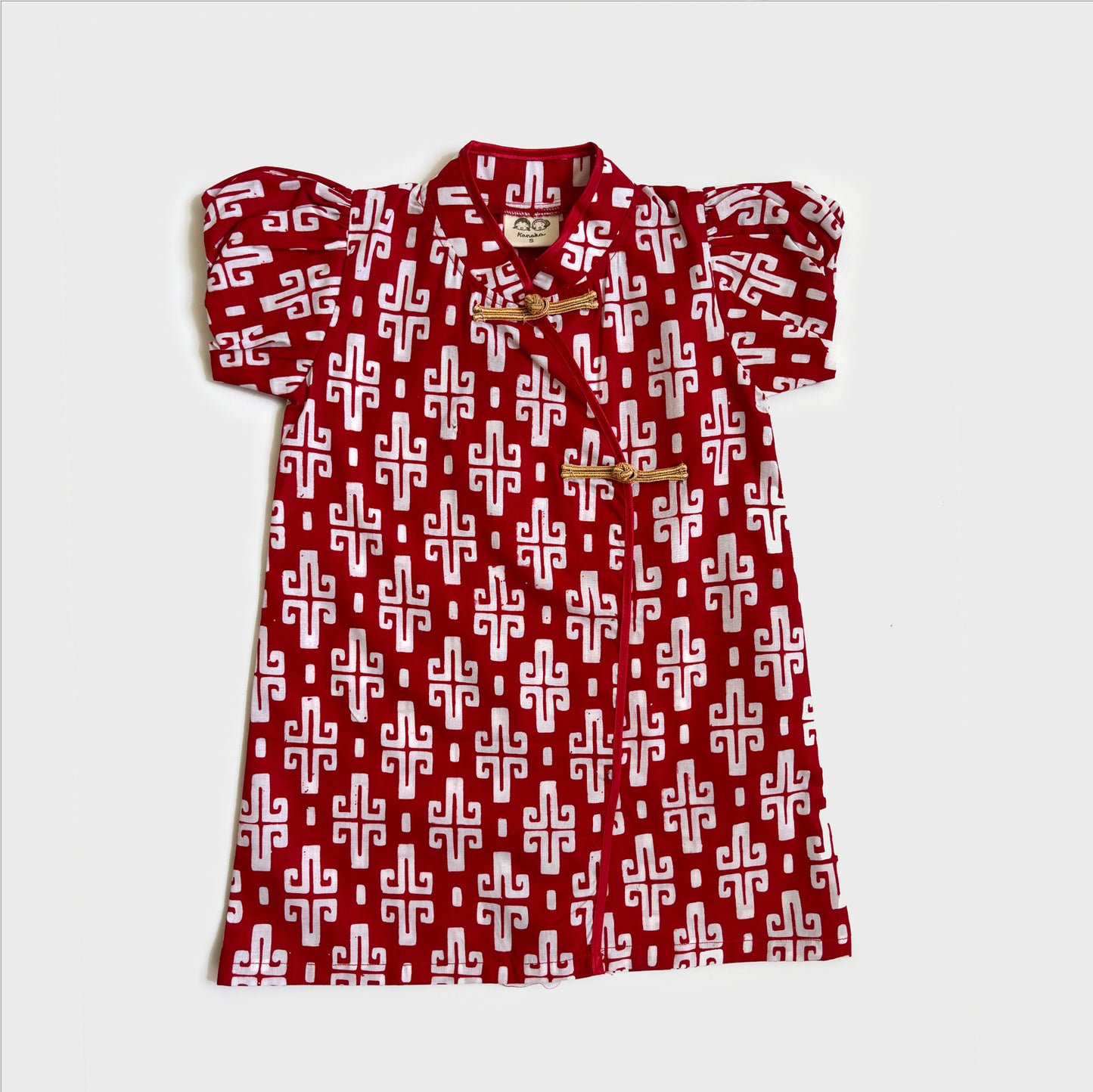 Red cheongsam batik dress with gold frog buttons in an ikat inspired print