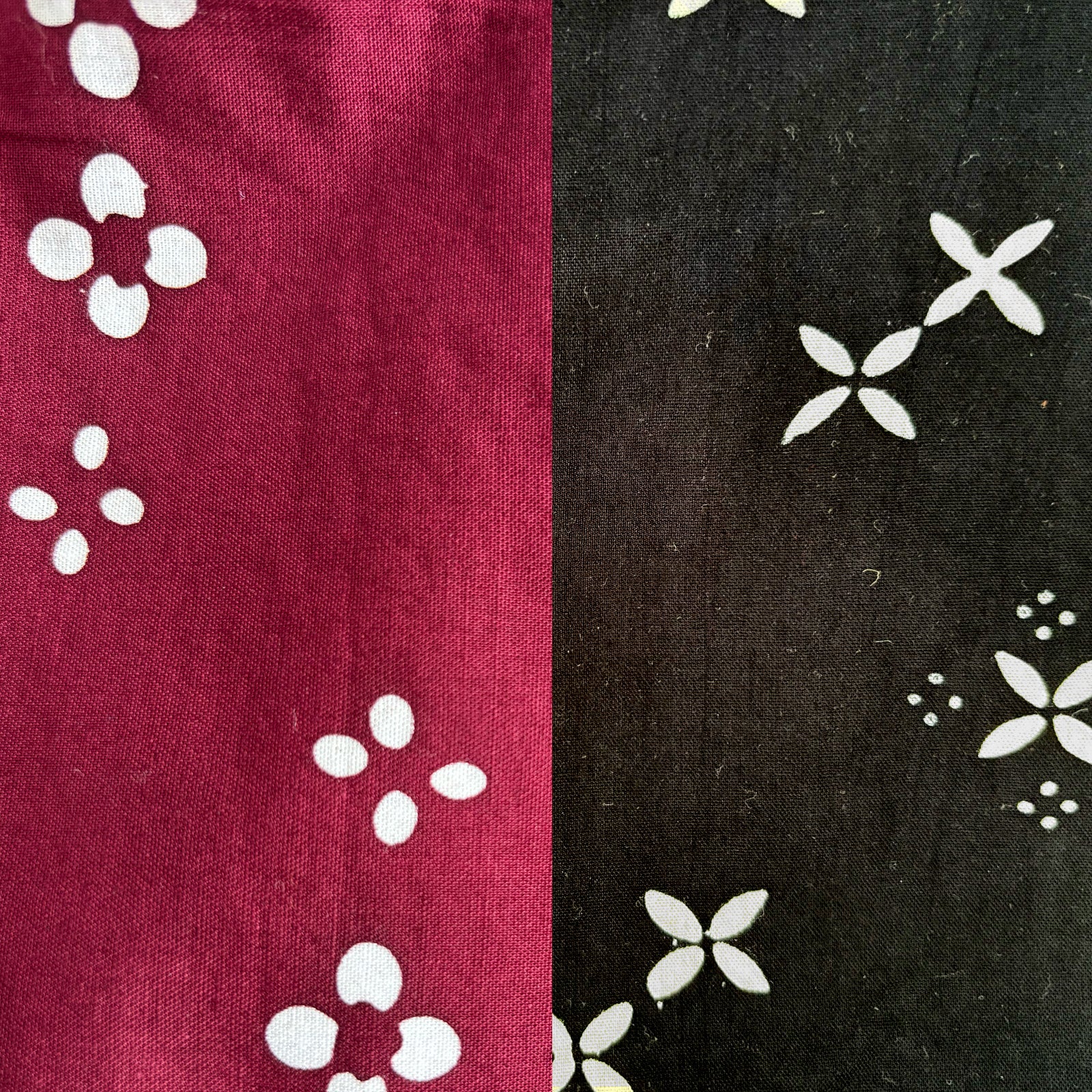 Two fabric swatches with white floral patterns, one on red and one on black.