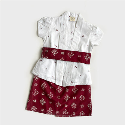 Red and white girl's kebaya outfit with white kartini top and red skirt