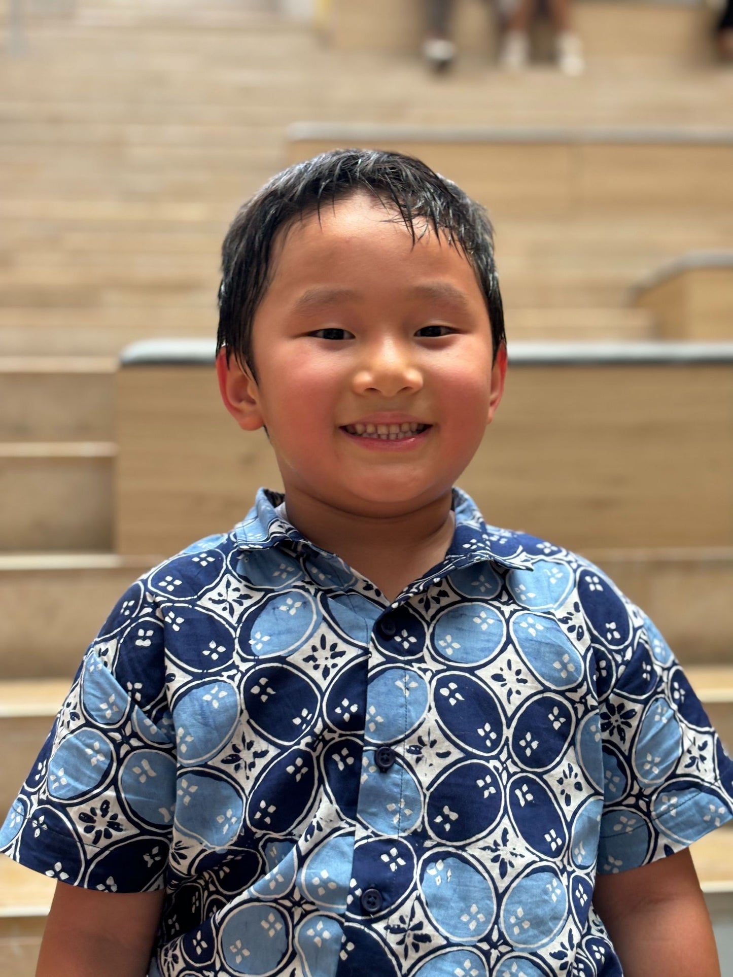 Model wears a two tone blue batik shirt and smiling