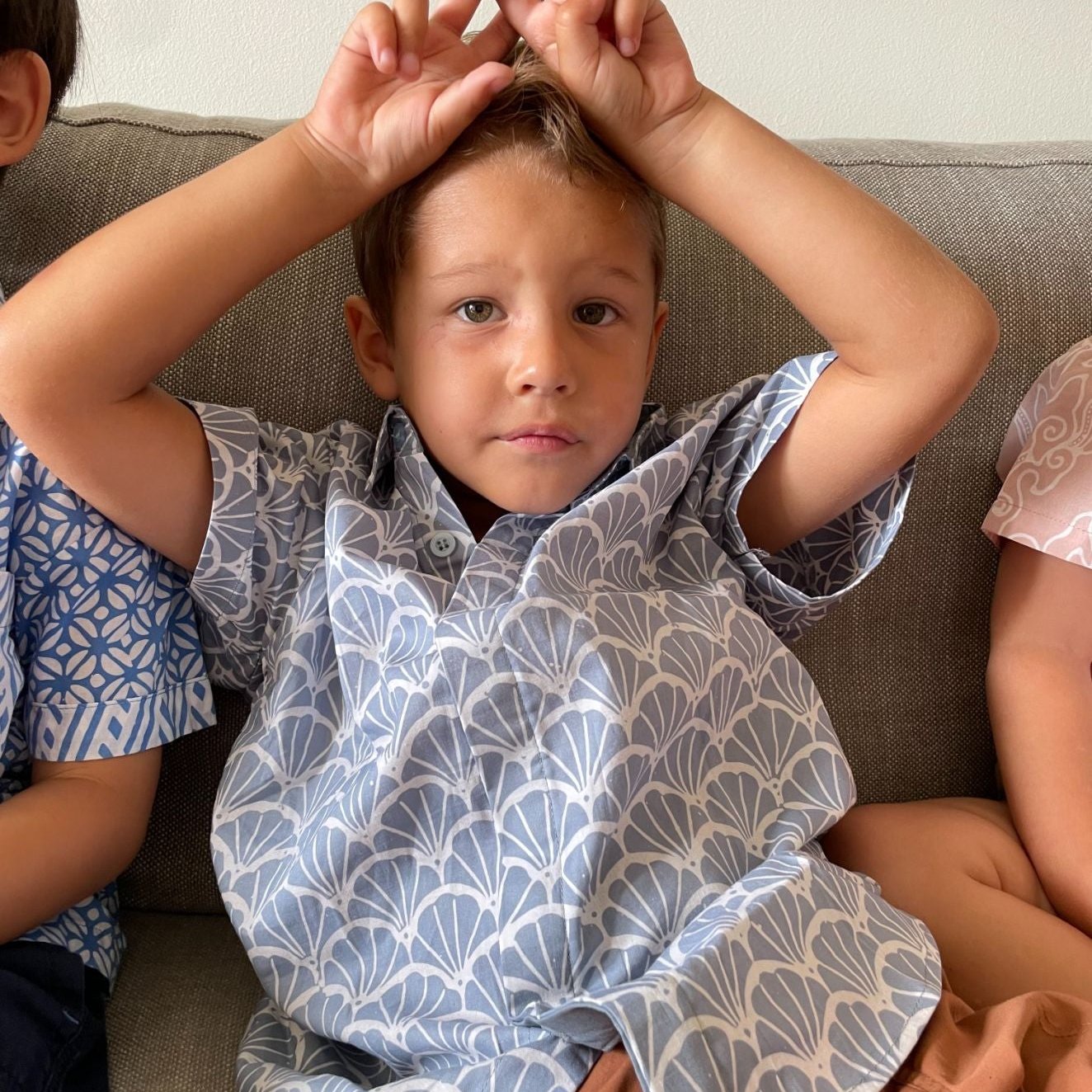 Boy wearing a grey batik shirt with a scallop print