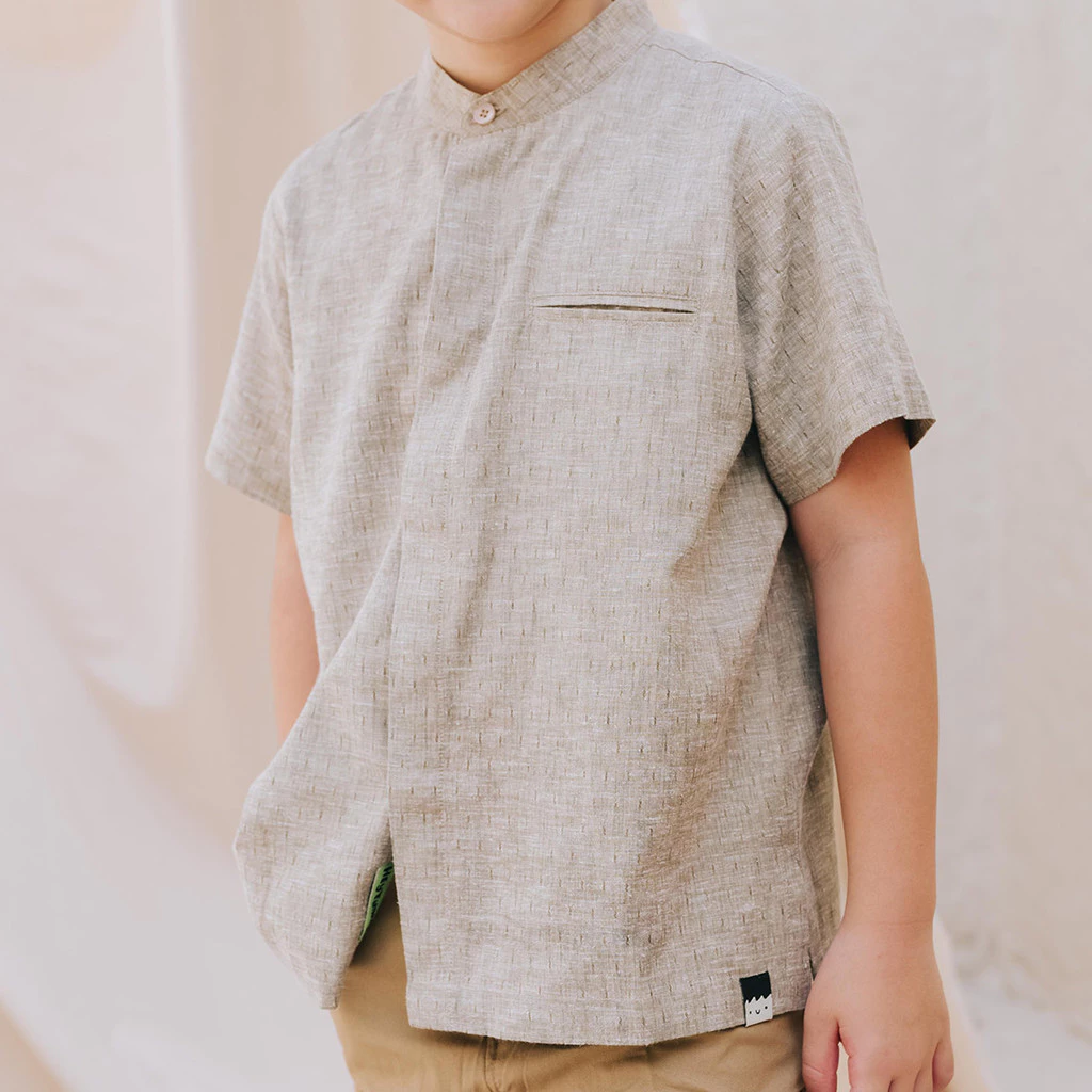 Close up of a beige cotton shirt with a high collar on a boy