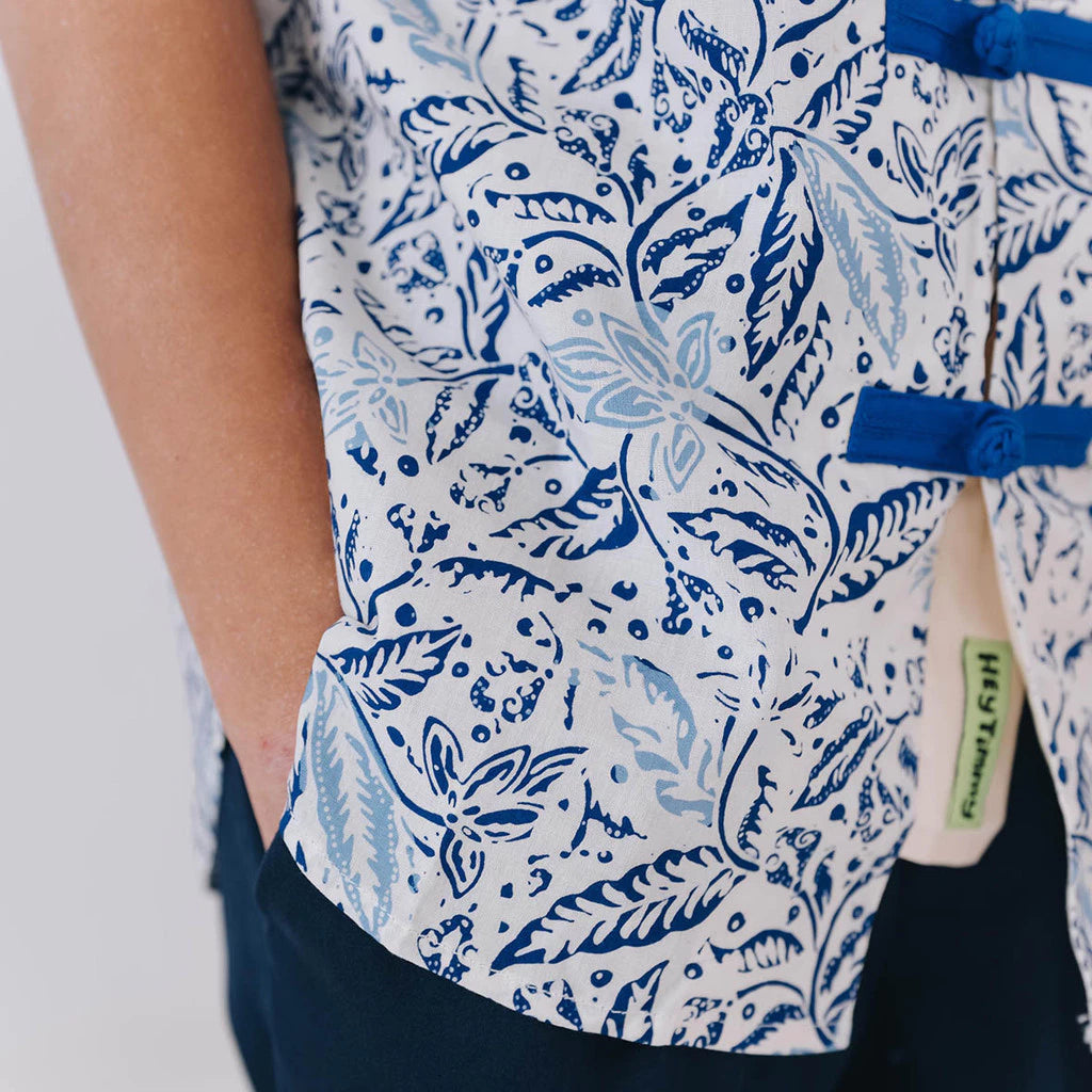 White batik shirt with blue floral pattern worn by a boy, with a visible brand tag.